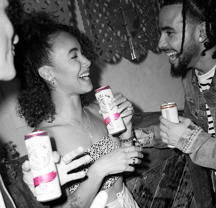 A group of friends enjoy some WHITE CLAW® at a beach house.