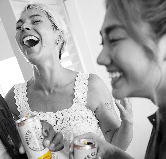 Two friends enjoying WHITE CLAW® Mango