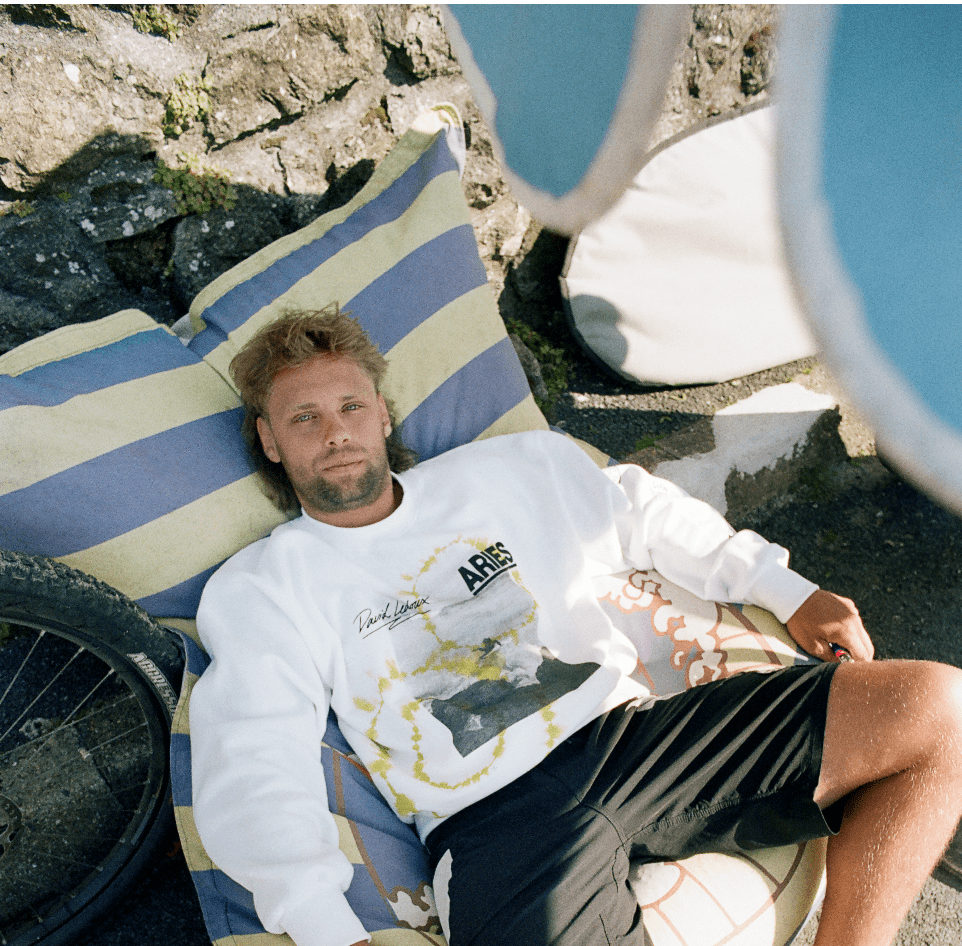 A man on a towel wears part of the WHITE CLAW® X Aries collaboration. 
