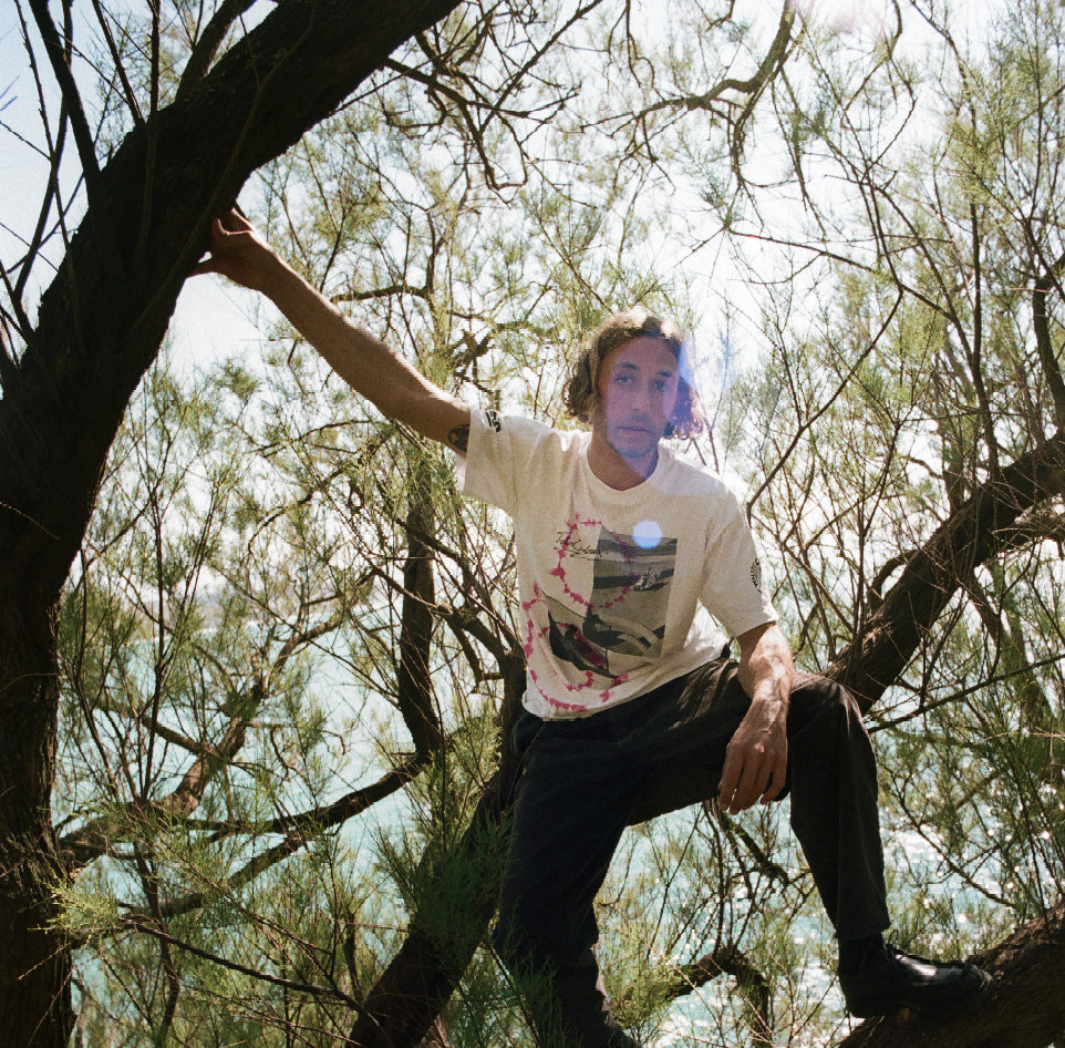 A man in a tree wears part of the WHITE CLAW® X Aries collaboration. 