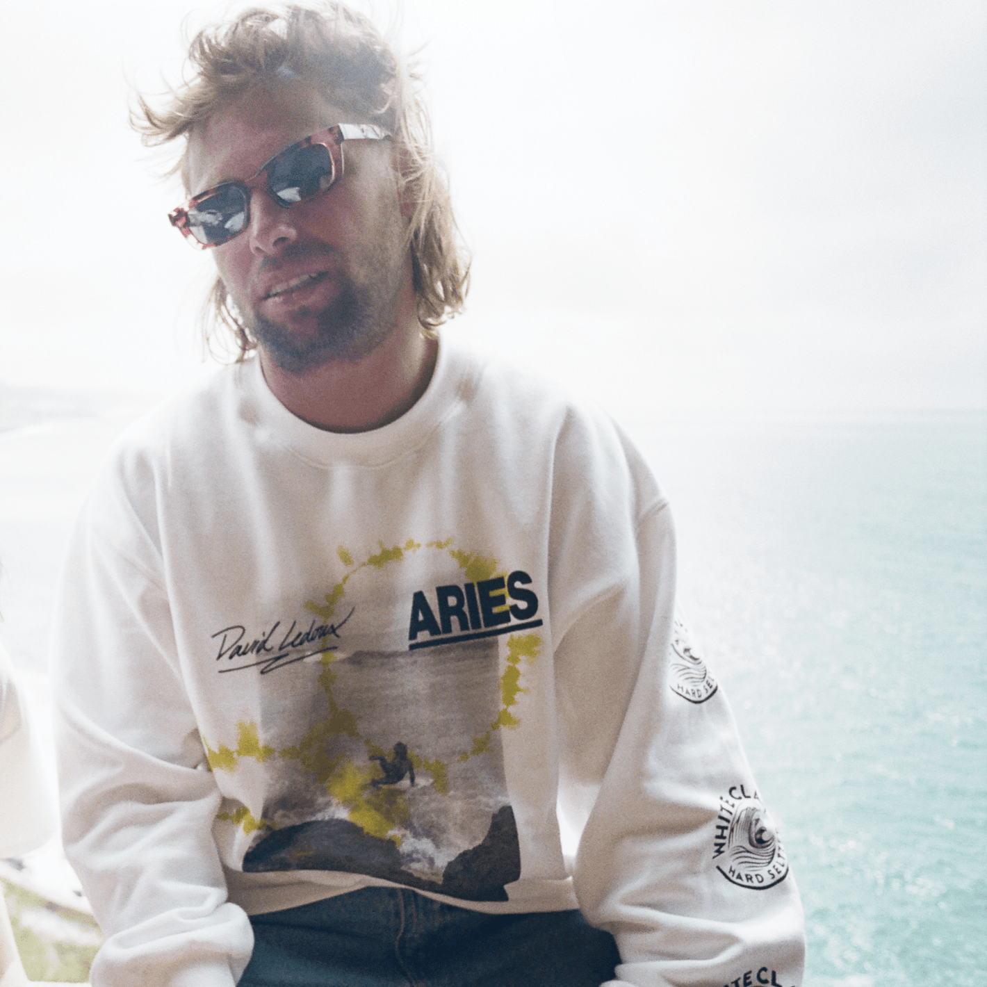 A man in white wears part of the WHITE CLAW® X Aries collaboration. 